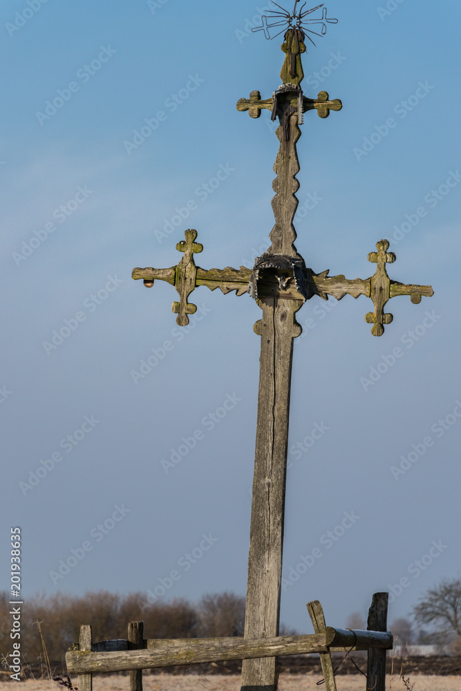 an old wooden decorated field cross standing amidst spring fields of puddles on a frosty morning an old wooden decorated field cross standing amidst spring fields of puddles on a frosty morning