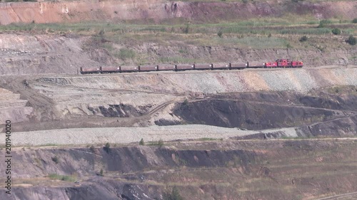 Coal pit with brown coal and freight train. photo