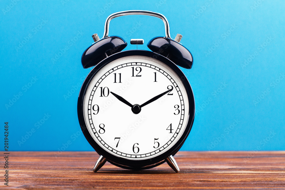 alarm clock on a color background on a wooden board alarm clock on a color background on a wooden board