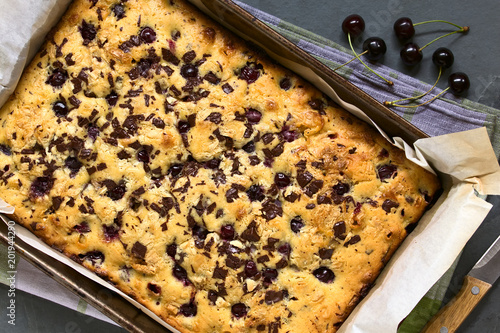 Cherry blondie or blond brownie cake baked with white and dark chocolate, photographed in baking pan overhead with natural light