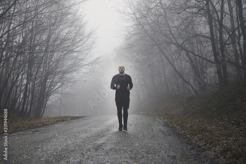 one runner jogging, outdoors mist fog, mysterious forest. © HD92