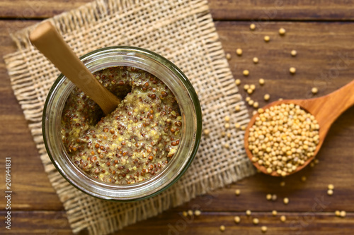 Fotografie, Obraz Whole grain mustard in glass jar, photographed overhead on wood natural light (S
