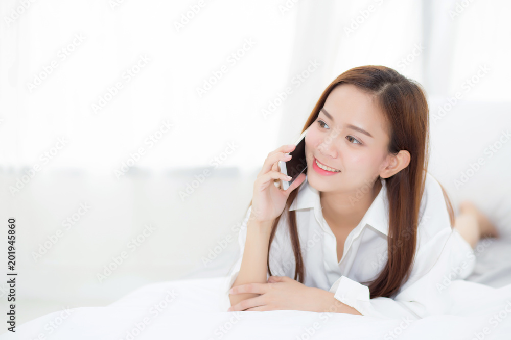 Beautiful young asian woman smiling lying and relax on the bed in the morning, girl using mobile smart phone talking enjoy, communication concept. Beautiful young asian woman smiling lying and relax on the bed in the morning, girl using mobile smart phone talking enjoy, communication concept.