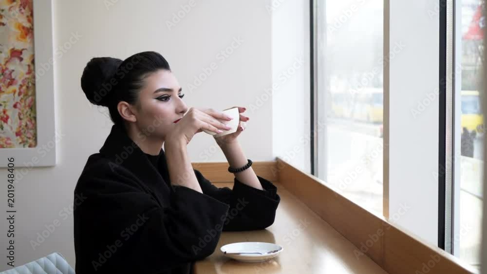 a young, beautiful woman drinking coffee a young, beautiful woman drinking coffee