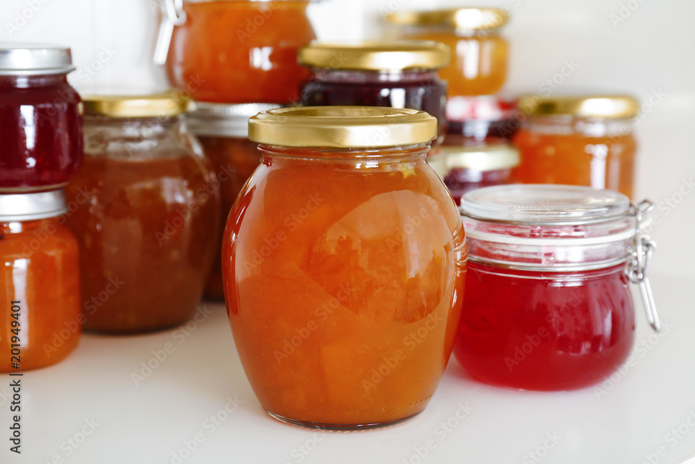 Jars with different sweet jam on table Jars with different sweet jam on table