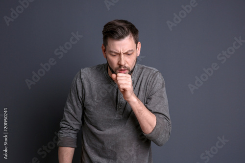 Mature man coughing on color background