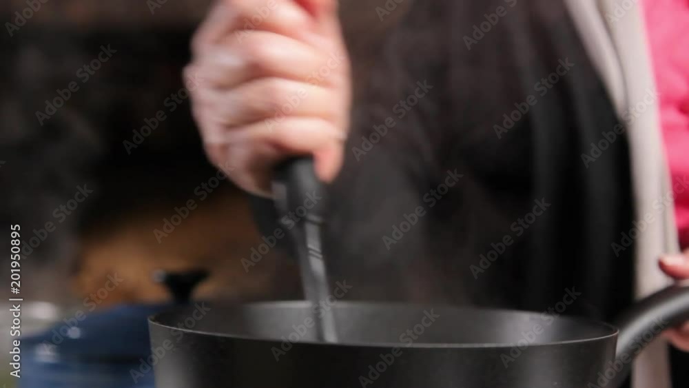 A close up shot of a woman smashing green pease in a pot. A close up shot of a woman smashing green pease in a pot.