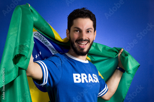 Supporter of National Team of football is holding the Brazil flag. photo