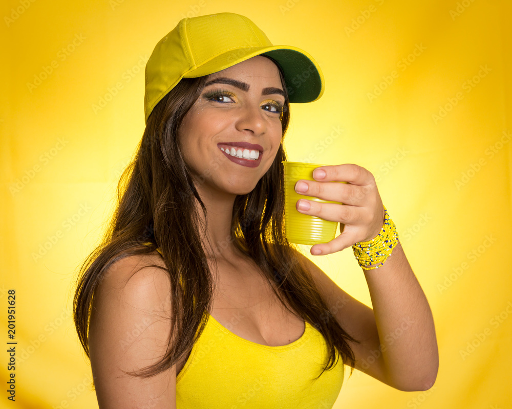 Brazilian woman fan celebrating on football match on yellow background. Brazilian woman fan celebrating on football match on yellow background.