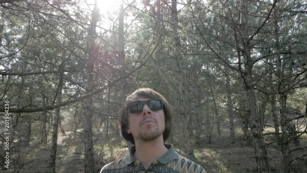 Young man walk alone in pines forest, hiker relaxing in forest in spring sunny day Young man walk alone in pines forest, hiker relaxing in forest in spring sunny day
