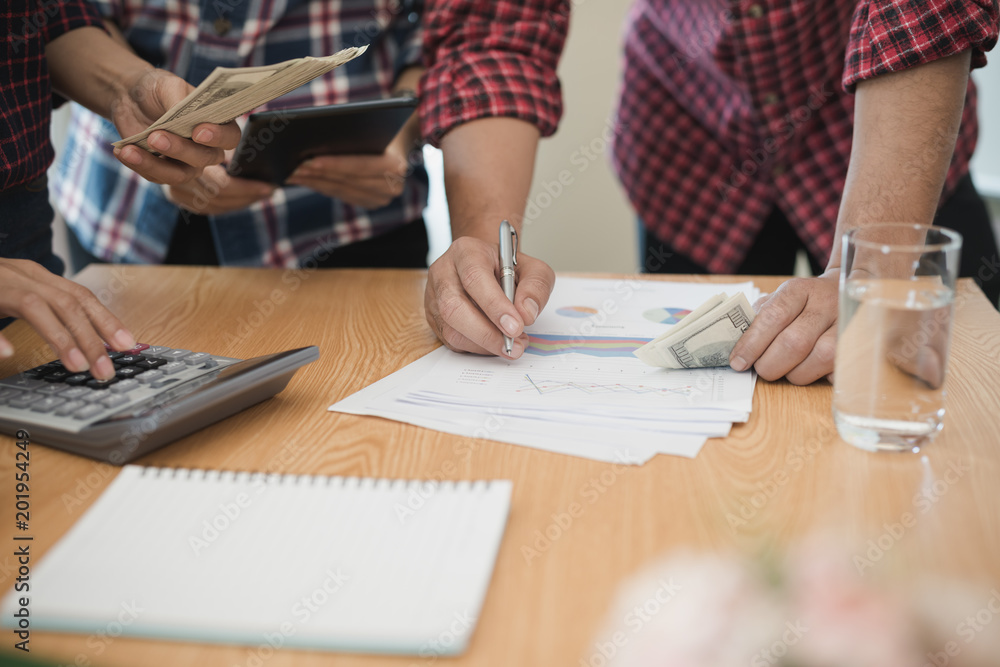 Group business man and woman use calculator. She is calculated the share of business Group business man and woman use calculator. She is calculated the share of business