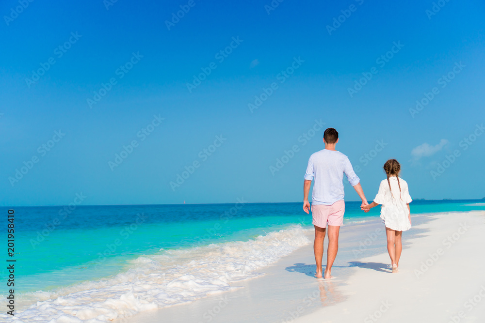 Happy father and his adorable little daughter at tropical beach having fun Happy father and his adorable little daughter at tropical beach having fun