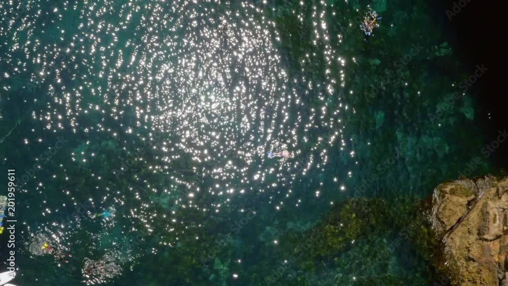 Birds eye view drone shot of woman snorkelling in sparkling water Birds eye view drone shot of woman snorkelling in sparkling water