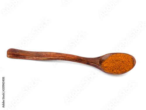 Dark wood spoon with ground red pepper isolated on white background.
