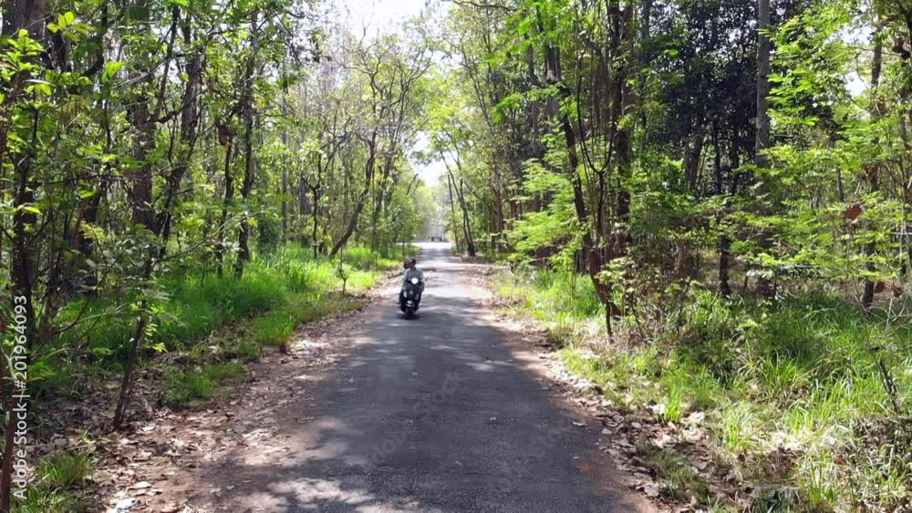 Slow motion Young Couple Riding Motor Scooter Along Country Road