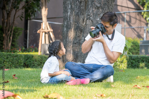 Father take photo with camera of daughter in house garden,family picnic activity.