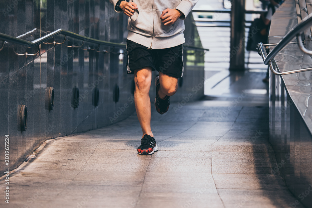 Close up of Young athletic man jogging on city bridge at the morning. Close up of Young athletic man jogging on city bridge at the morning.