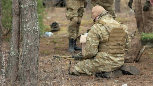 Soldiers in camouflage prepare for battle and check out equipment and weapons photo