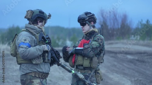 Soldiers in camouflage with military weapons rest in the shelter of the forest, the military concept photo