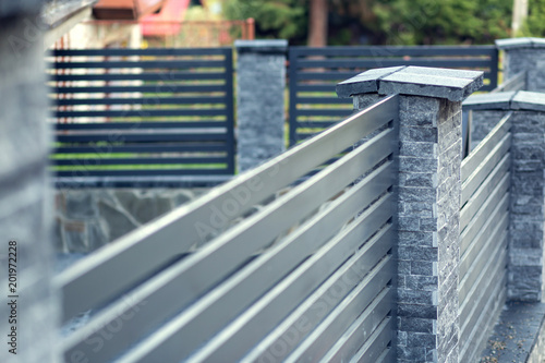 Obraz na plátně Modern fence with stone pillars and metal filling