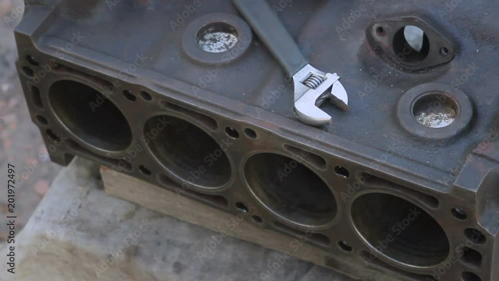 Close-up of a dismantled car engine box and a wrench