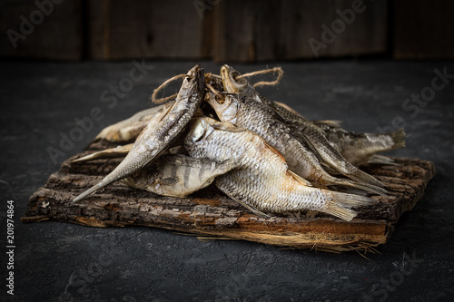 Dried fish lies on dark stone surface