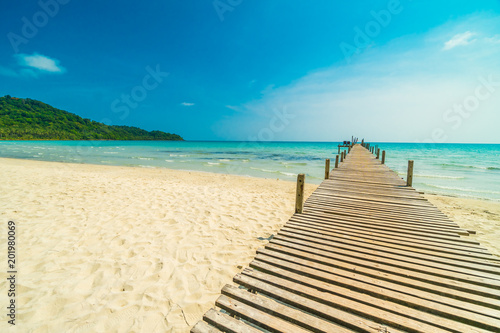 Fototapeta Naklejka Na Ścianę i Meble -  Wooden pier or bridge with tropical beach and sea in paradise island