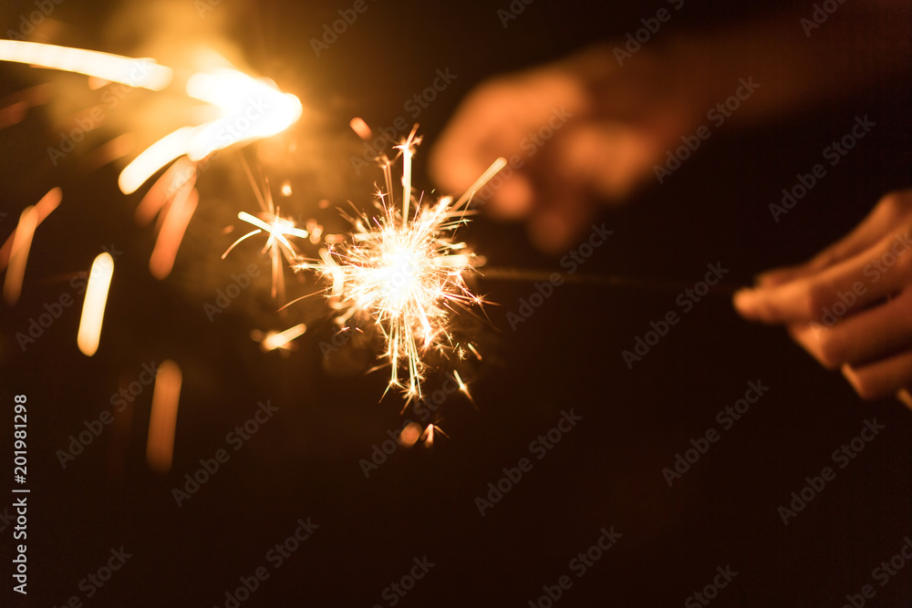 Blurred of Sparklers for celebration. Friends hand holding a burn