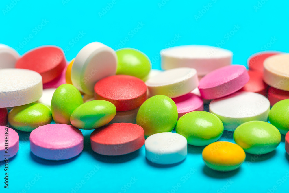 Pills are scattered over a blue background Pills are scattered over a blue background