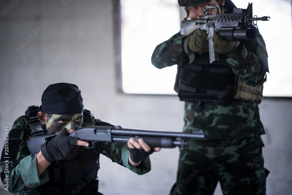 Fototapeta premium Asian army soldier with rifle and machine gun moving patriol around building.