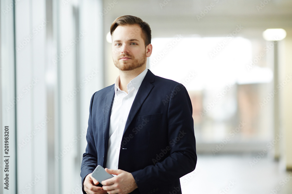 Portrait of confident businessman in suit standing at office Portrait of confident businessman in suit standing at office