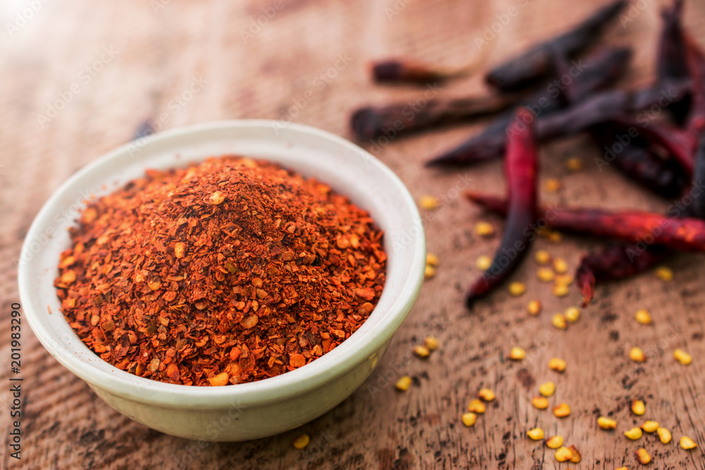 Close up of Cayenne pepper in bowl on wooden background Close up of Cayenne pepper in bowl on wooden background