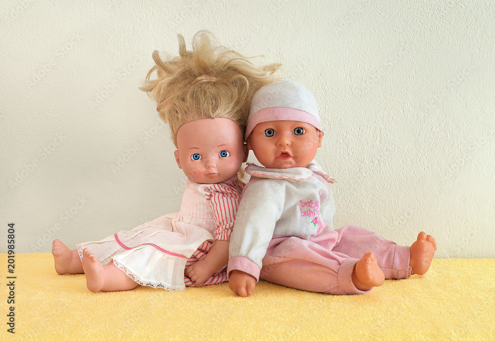 Tiny tots dolls in pink clothes. Nursery dolls sitting back to