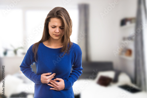 Young woman suffering stomach ache. photo