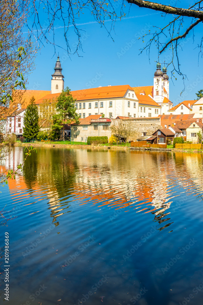 View at the building of church in old city Telc with Ulicky pond - Czech republic, Moravia View at the building of church in old city Telc with Ulicky pond - Czech republic, Moravia