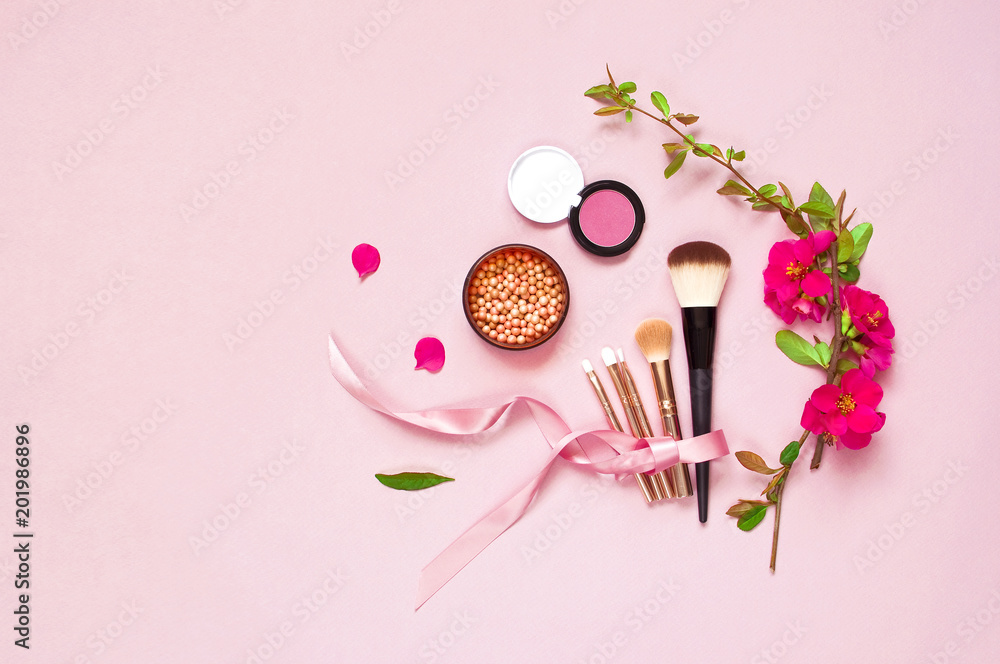 Various brushes for make-up and pink spring flowers on a pink pastel background top view with copy space. Makeup Accessories Top Flat Lay Various brushes for make-up and pink spring flowers on a pink pastel background top view with copy space. Makeup Accessories Top Flat Lay