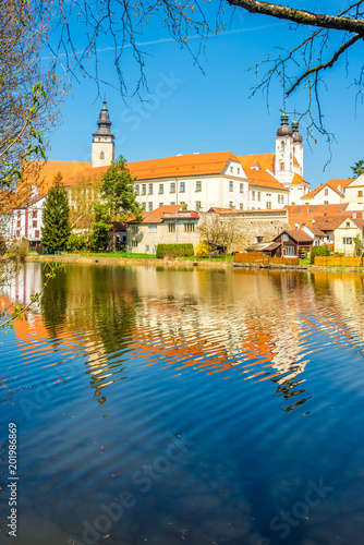 View at the building of church in old city Telc with Ulicky pond - Czech republic, Moravia