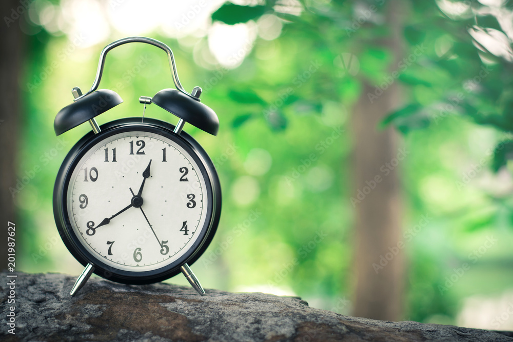Black alarm clock on nature background with copy space Stock Photo