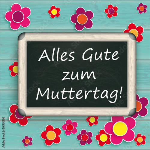 Kreidetafel auf türkisfarbenen Holztisch mit dem Text Alles Gute Zum Muttertag