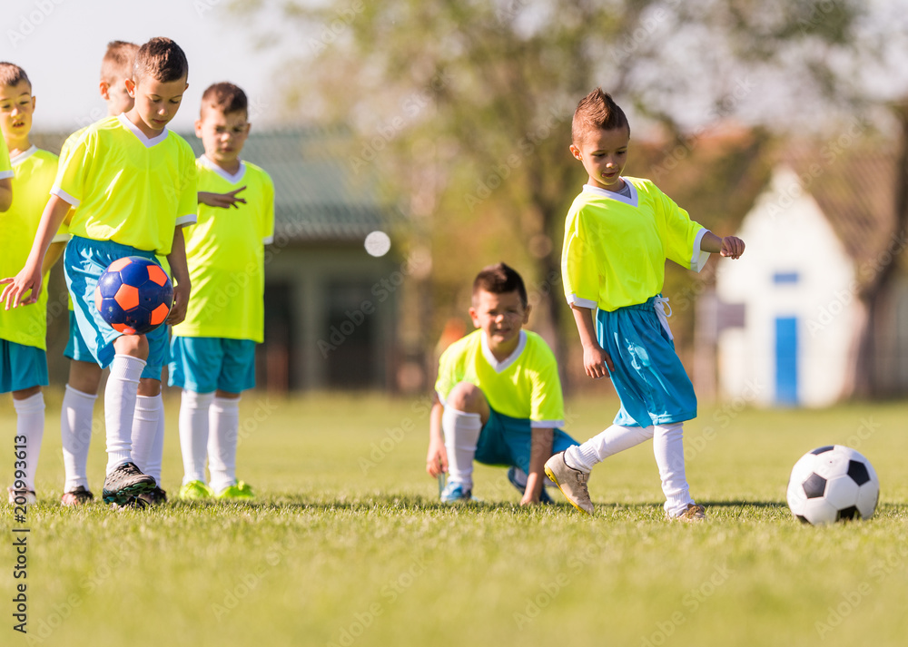 Fototapeta premium Young children players football match on soccer field
