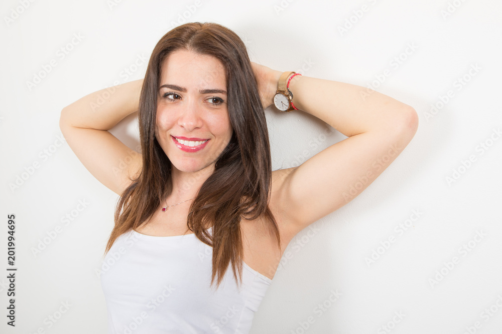 smiiling woman leaning against the white wall smiiling woman leaning against the white wall