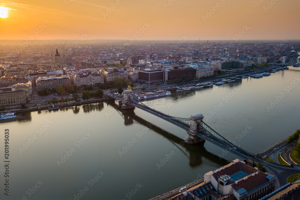 Budapest, Hungary - Beautiful Szechenyi Chain Bridge over River Danube at sunrise with St. Stephen's Basilica and skyline of Pest side of Budapest
