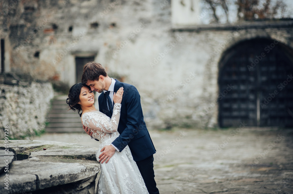 Sensual married couple, valentines hugging in front of old slavi Sensual married couple, valentines hugging in front of old slavi