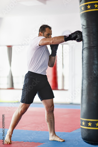 Kickbox fighter training in a gym with punch bags, see the whole series © czamfir