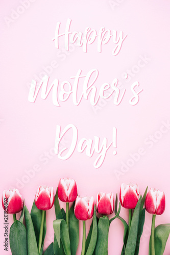 Mother's day greeting card with tulips on pink background. Top view.