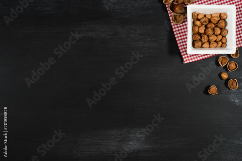 Hazelnuts in a white bowl on the chalkboard.