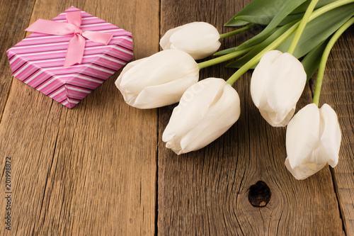 Fototapeta Naklejka Na Ścianę i Meble -  White tulips with gift on old wooden table.