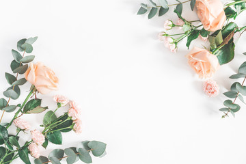 Flowers composition. Frame made of rose flowers and eucalyptus branches on white background. Flat lay, top view, copy space