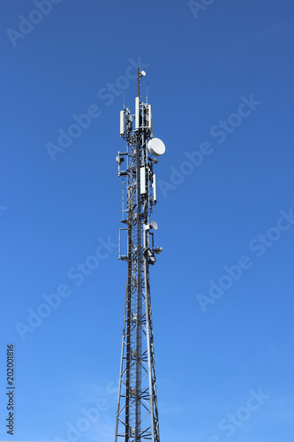Radio tower with antennas on a blue sky background. Metal construction. Wireless tezhnologii. Transmission of a tele-radio signal. Egology of the external environment. copyspace.