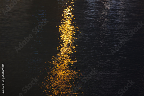 Light of lanterns on the smooth surface of water at night as a background